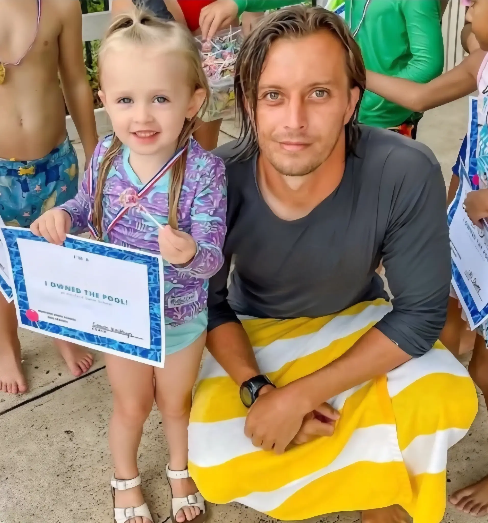 Swimming instructor with student holding I OWNED THE POOL certificate at Endless Summer Swim School